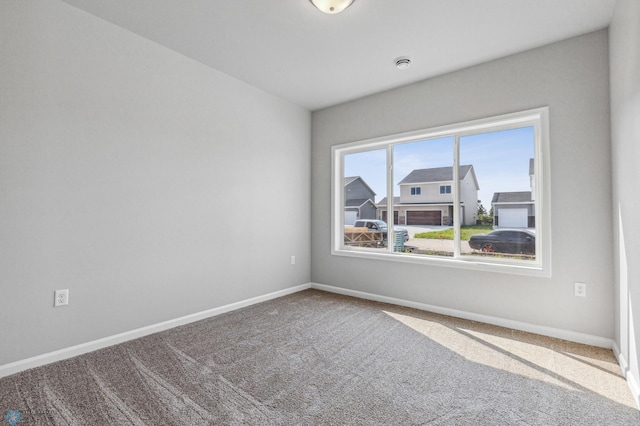 spare room with baseboards and carpet flooring