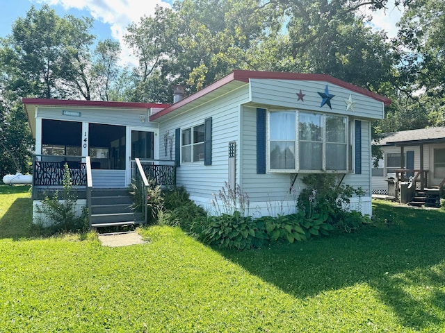 rear view of house featuring a yard