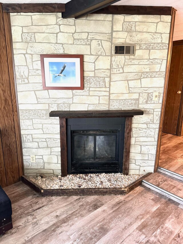 details with a stone fireplace and hardwood / wood-style flooring