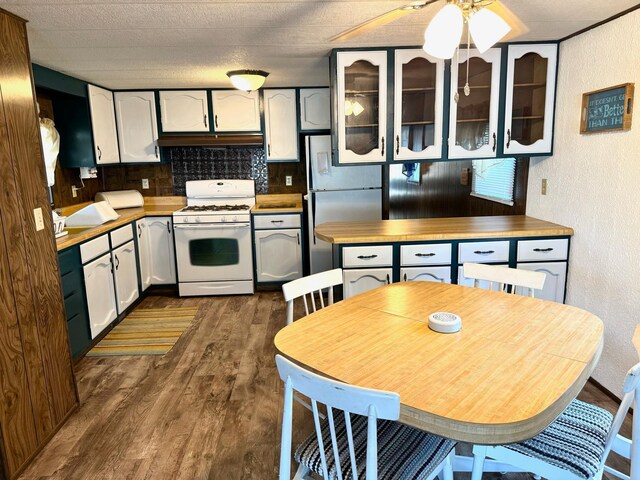 2769 28th St NW Unit 140, Wheeler Twp, MN 56623 - kitchen with white range with gas stovetop, glass insert cabinets, freestanding refrigerator, dark wood-style flooring, and a textured wall