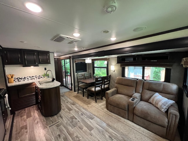 living area featuring a wealth of natural light, visible vents, and light wood-type flooring