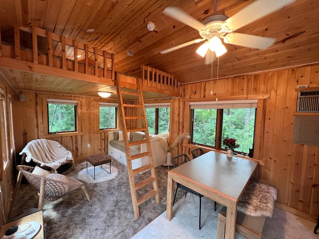 dining room featuring wood walls, a healthy amount of sunlight, and wood ceiling