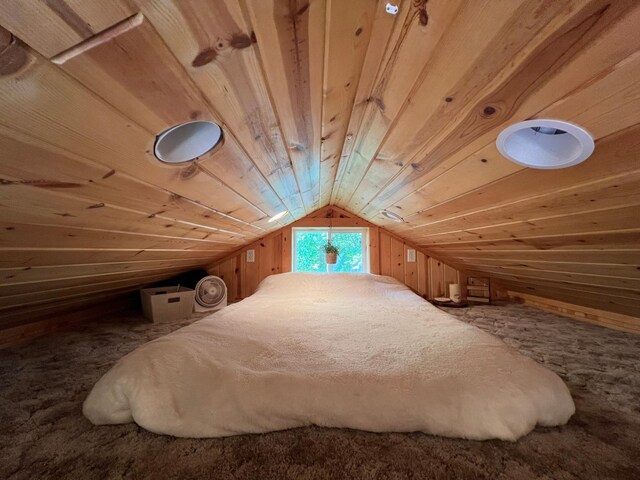 carpeted bedroom featuring lofted ceiling, wood walls, and wooden ceiling