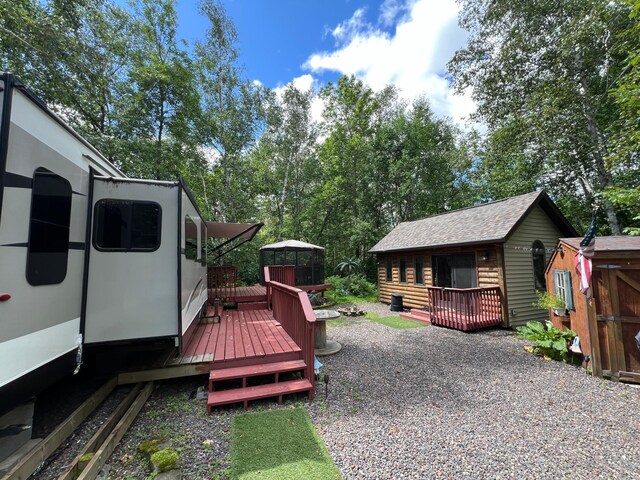view of yard featuring an outbuilding, a deck, and a storage shed