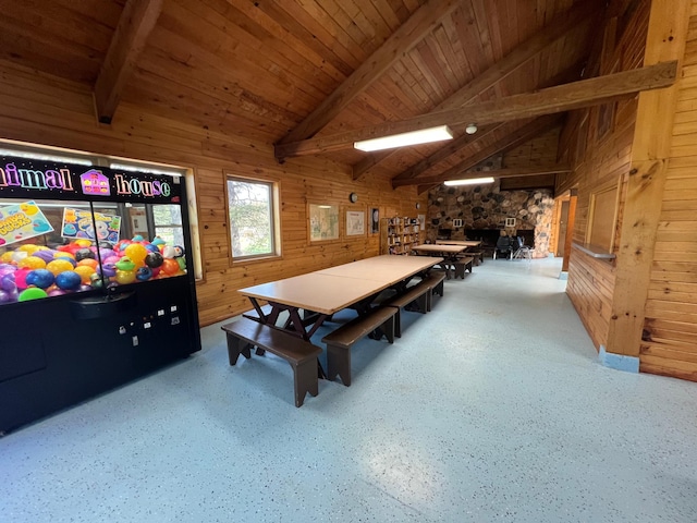 playroom with wood ceiling, vaulted ceiling with beams, speckled floor, and wooden walls