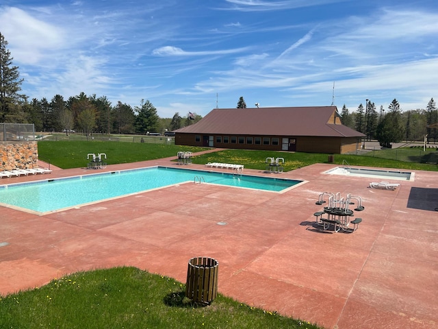 community pool with fence, a yard, and a patio