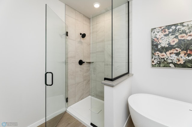 bathroom with wood-type flooring and separate shower and tub