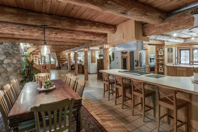 dining room featuring light tile patterned floors, wood ceiling, and beamed ceiling