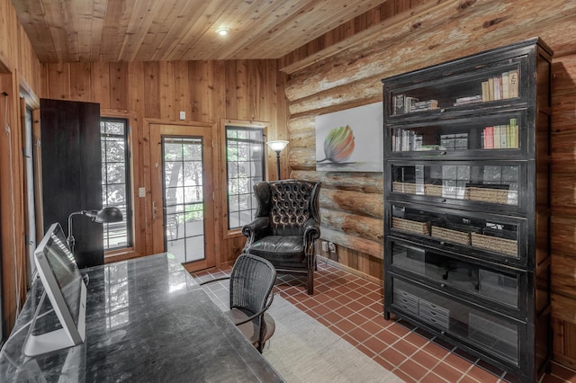 interior space with dark tile patterned floors, wood ceiling, wooden walls, and log walls