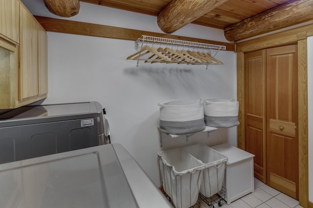 clothes washing area featuring light tile patterned floors, washing machine and dryer, wood ceiling, and cabinets