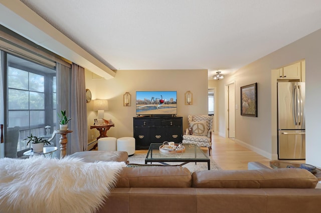 living room with plenty of natural light, beamed ceiling, and light hardwood / wood-style floors