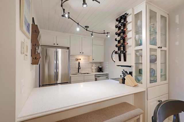 kitchen with a breakfast bar area, appliances with stainless steel finishes, sink, and white cabinetry