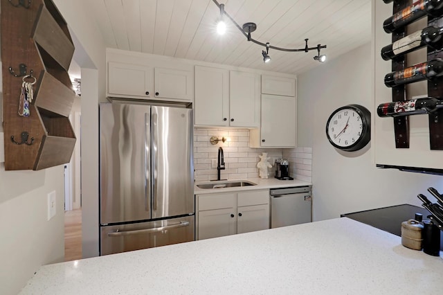 kitchen with sink, white cabinets, stainless steel appliances, and rail lighting