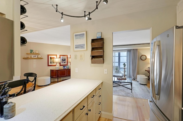 kitchen featuring stainless steel fridge, track lighting, and light wood-type flooring