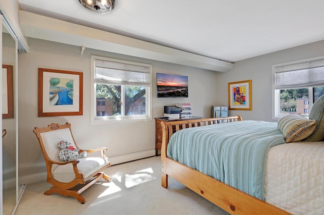 bedroom with light carpet, multiple windows, and a baseboard radiator