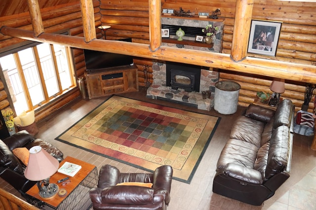 living room featuring a wood stove, hardwood / wood-style flooring, and rustic walls