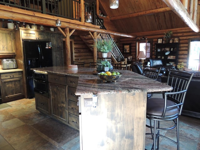 kitchen featuring black appliances, wood ceiling, a breakfast bar, and log walls