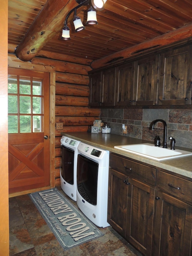 laundry area with cabinets, rustic walls, washer and dryer, wood ceiling, and sink