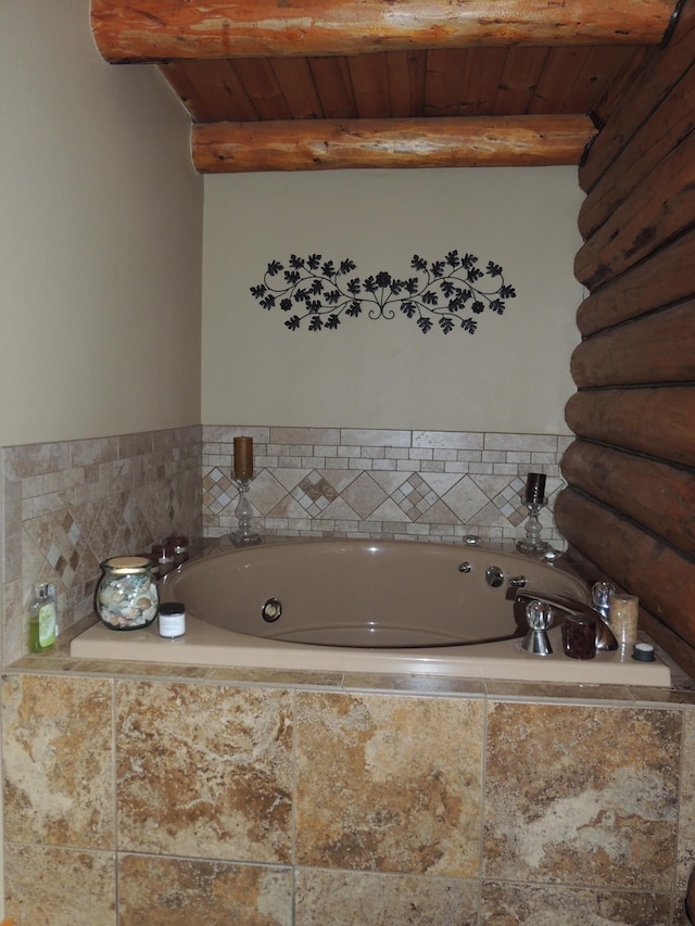 bathroom featuring a relaxing tiled tub, beamed ceiling, and wooden ceiling