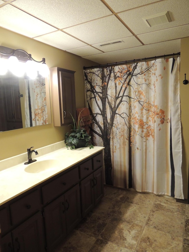 bathroom with a drop ceiling and vanity