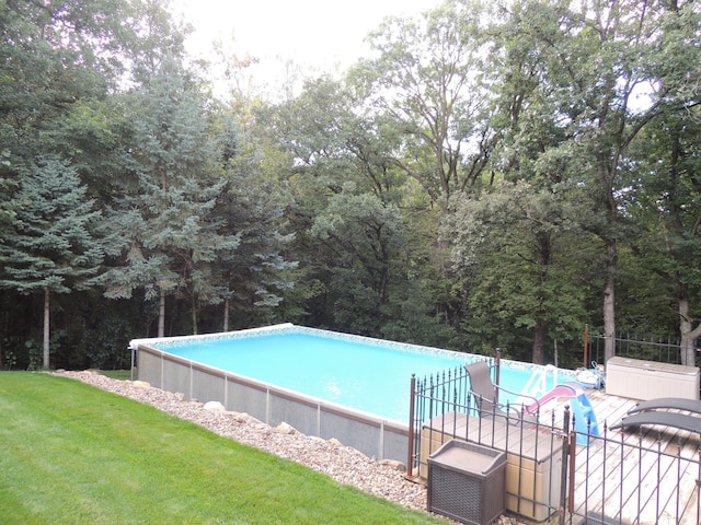 view of pool featuring a lawn