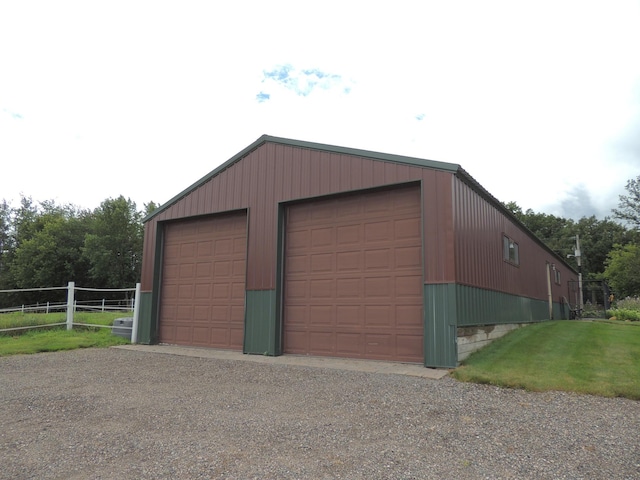 garage with a yard and wooden walls