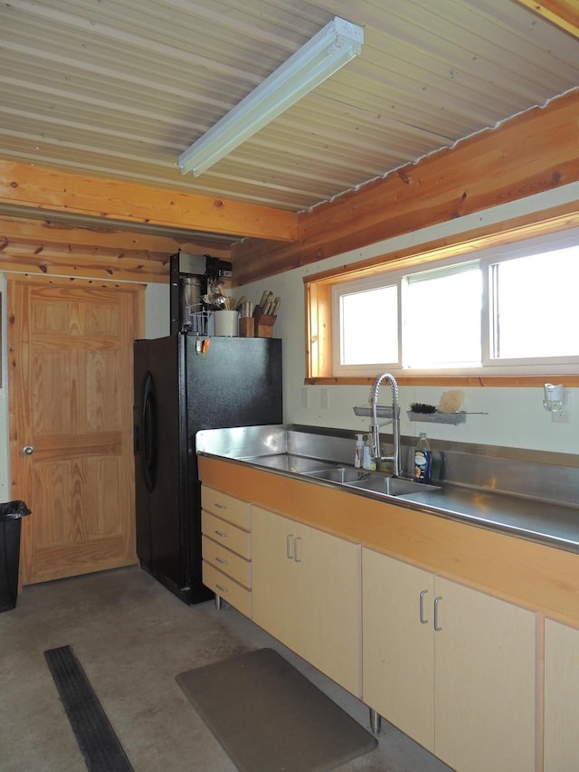 kitchen with black fridge, stainless steel counters, and sink