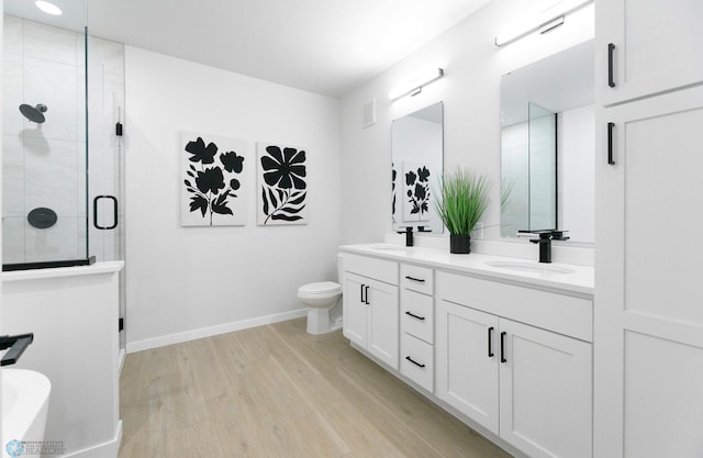 bathroom featuring hardwood / wood-style flooring, vanity, toilet, and walk in shower