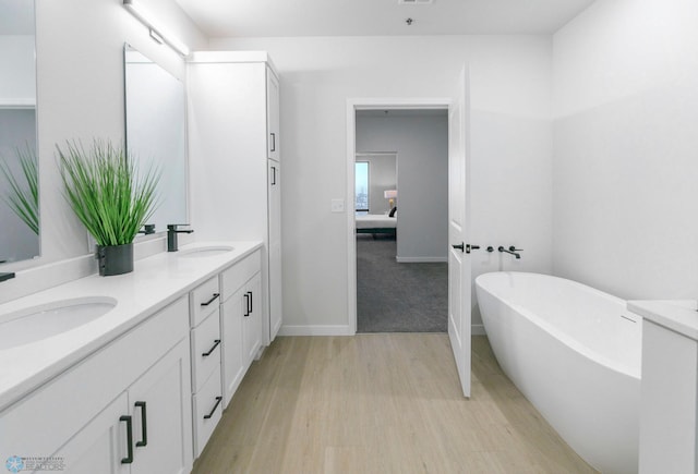 bathroom featuring vanity, hardwood / wood-style floors, and a bathtub