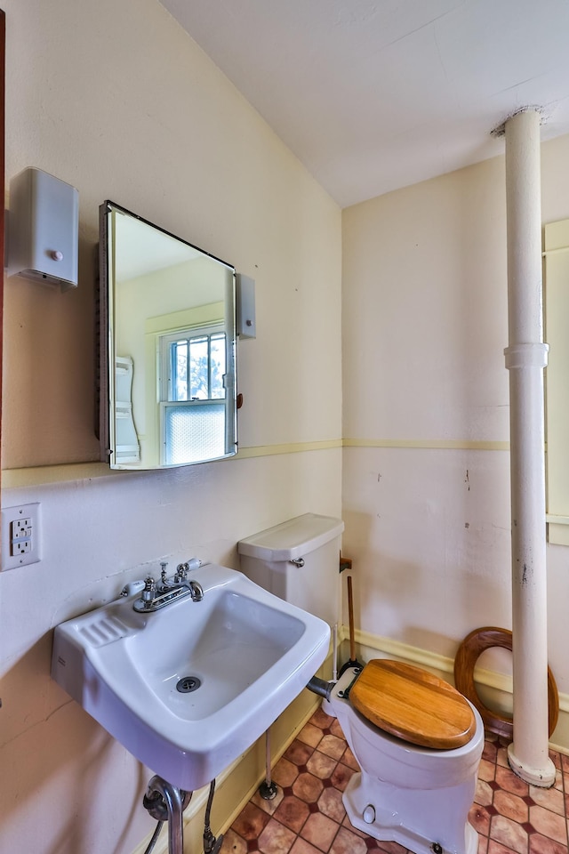 bathroom featuring toilet, sink, and tile patterned floors