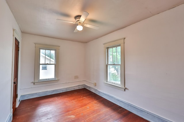 unfurnished room with dark wood-type flooring, ceiling fan, and a wealth of natural light