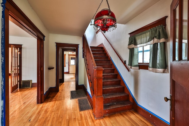 staircase featuring a notable chandelier and wood-type flooring