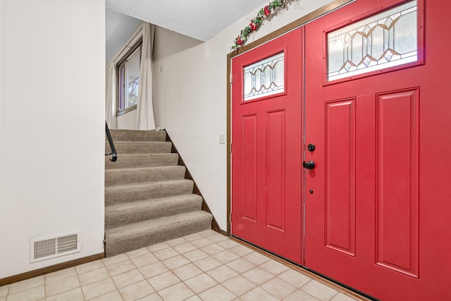 entrance foyer with light tile patterned floors and a textured ceiling