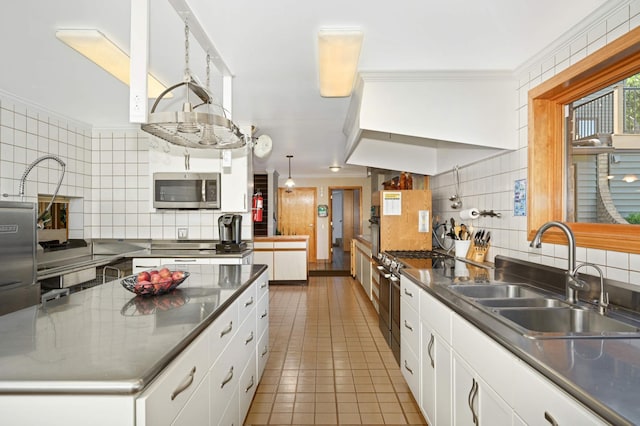 kitchen featuring sink, tile patterned floors, tasteful backsplash, white cabinetry, and stainless steel appliances