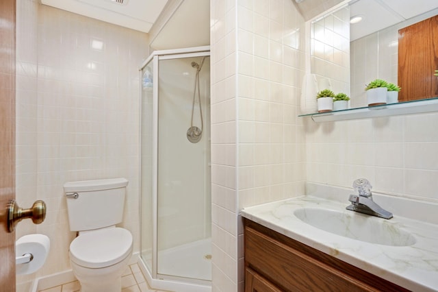 bathroom with tile patterned floors, toilet, vanity, and tile walls