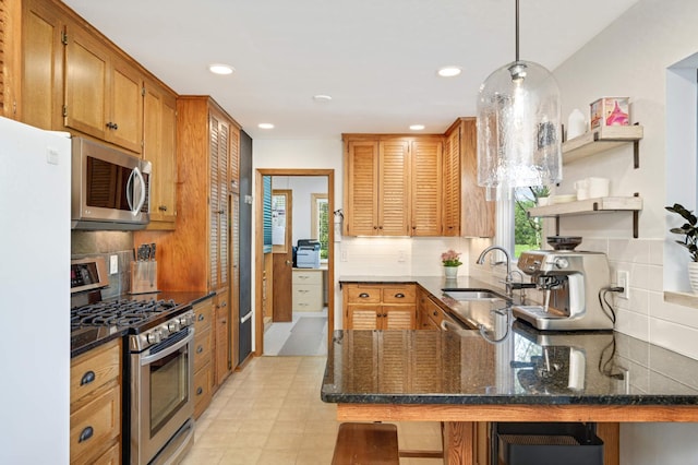 kitchen featuring appliances with stainless steel finishes, kitchen peninsula, and backsplash