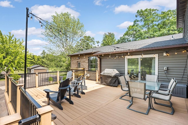 deck with an outdoor structure and area for grilling