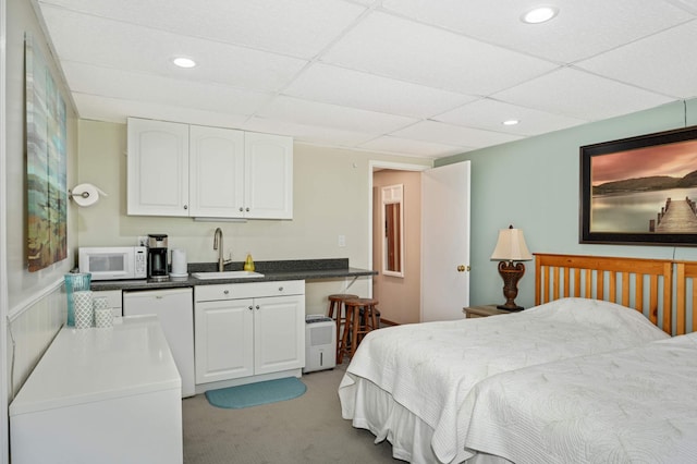 carpeted bedroom with sink and a paneled ceiling