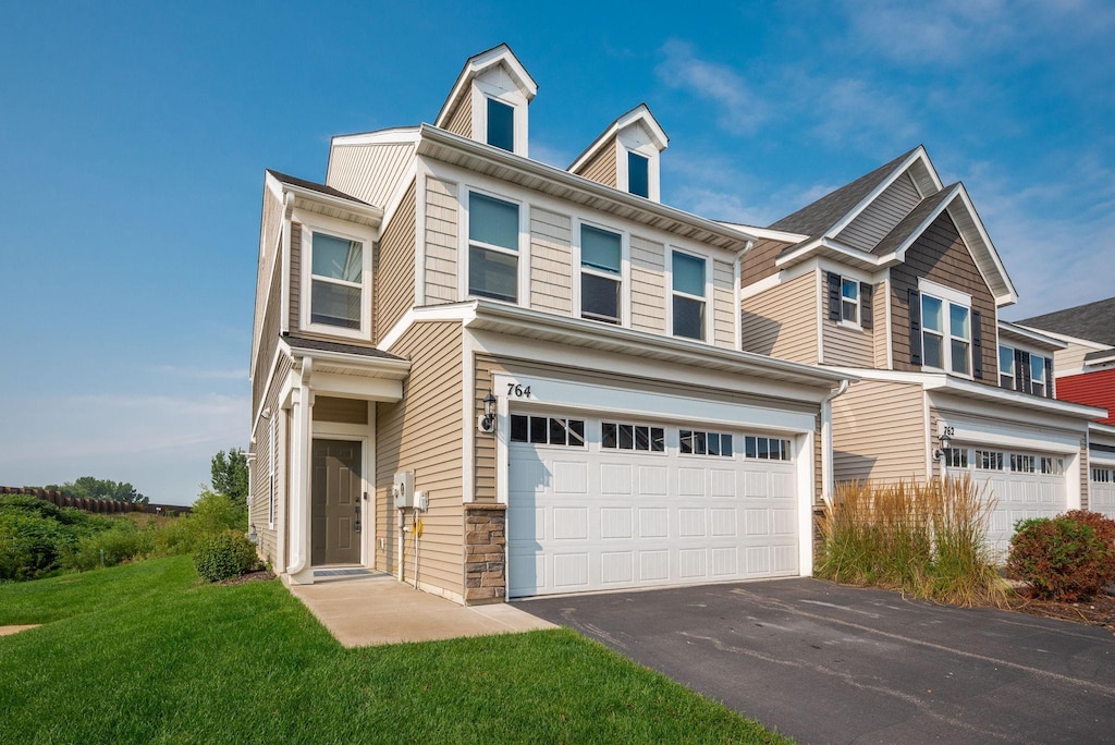 multi unit property with a garage and a front lawn