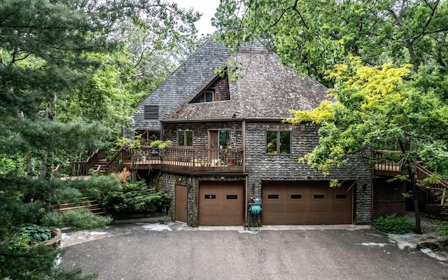 tudor-style house with a garage and a wooden deck