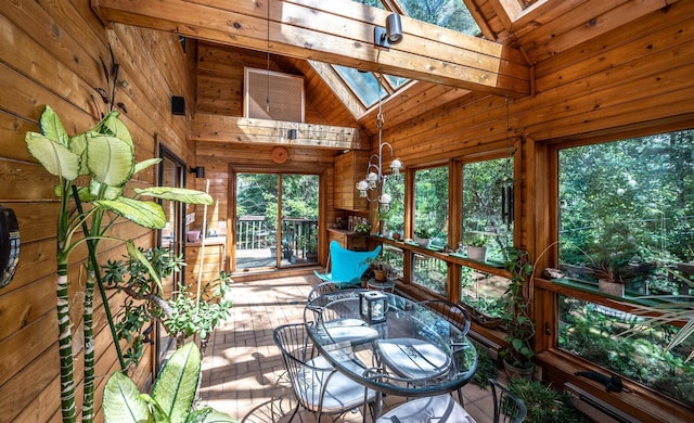 unfurnished sunroom with vaulted ceiling with skylight