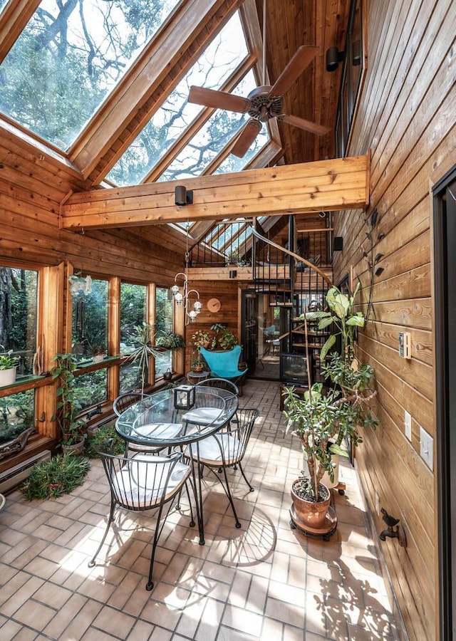 sunroom featuring ceiling fan and lofted ceiling with skylight