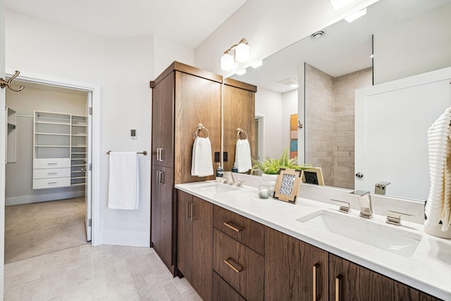 bathroom featuring tiled shower, tile patterned flooring, and vanity