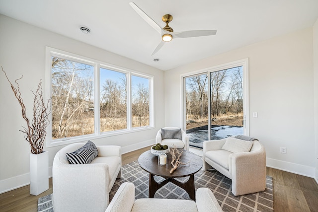 living area with ceiling fan and dark hardwood / wood-style floors