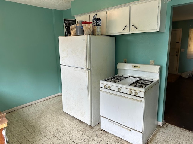 kitchen featuring white cabinets, light tile patterned flooring, and white appliances