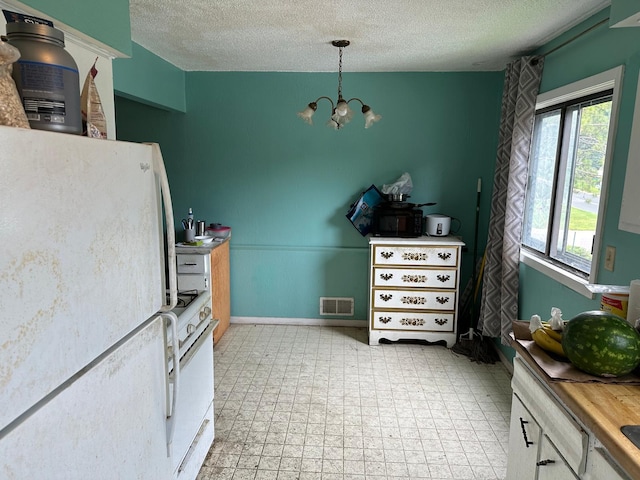 kitchen featuring a notable chandelier, plenty of natural light, white appliances, and light tile patterned floors