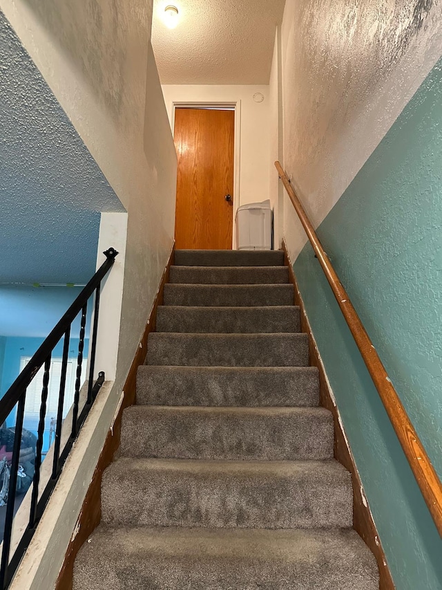 stairs featuring a textured ceiling