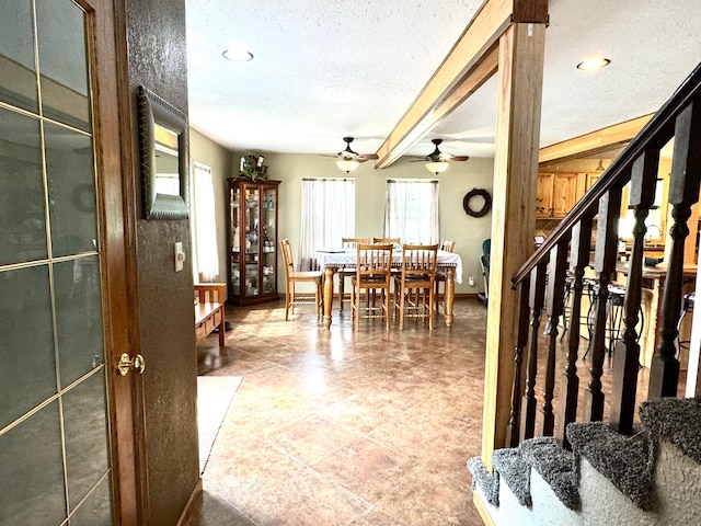 interior space featuring ceiling fan, a textured ceiling, and beamed ceiling