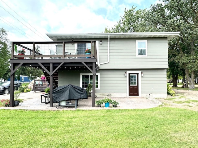 rear view of house featuring a lawn, a balcony, and a patio