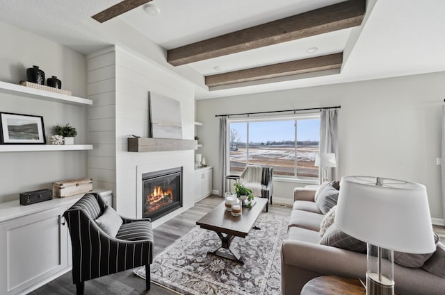 living room featuring a fireplace, hardwood / wood-style floors, and beam ceiling